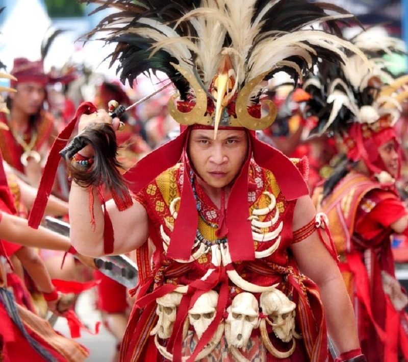 Minahasa warrior in kabrate dress with a horned feathered headdress